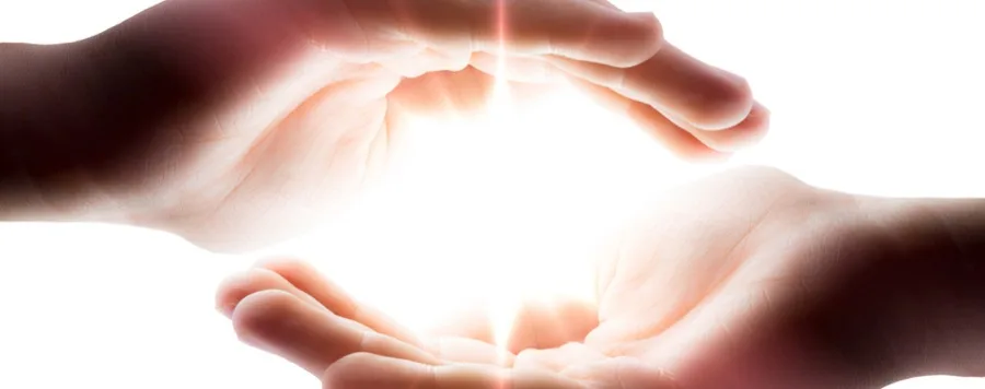 Hands channeling healing light during a Reiki session